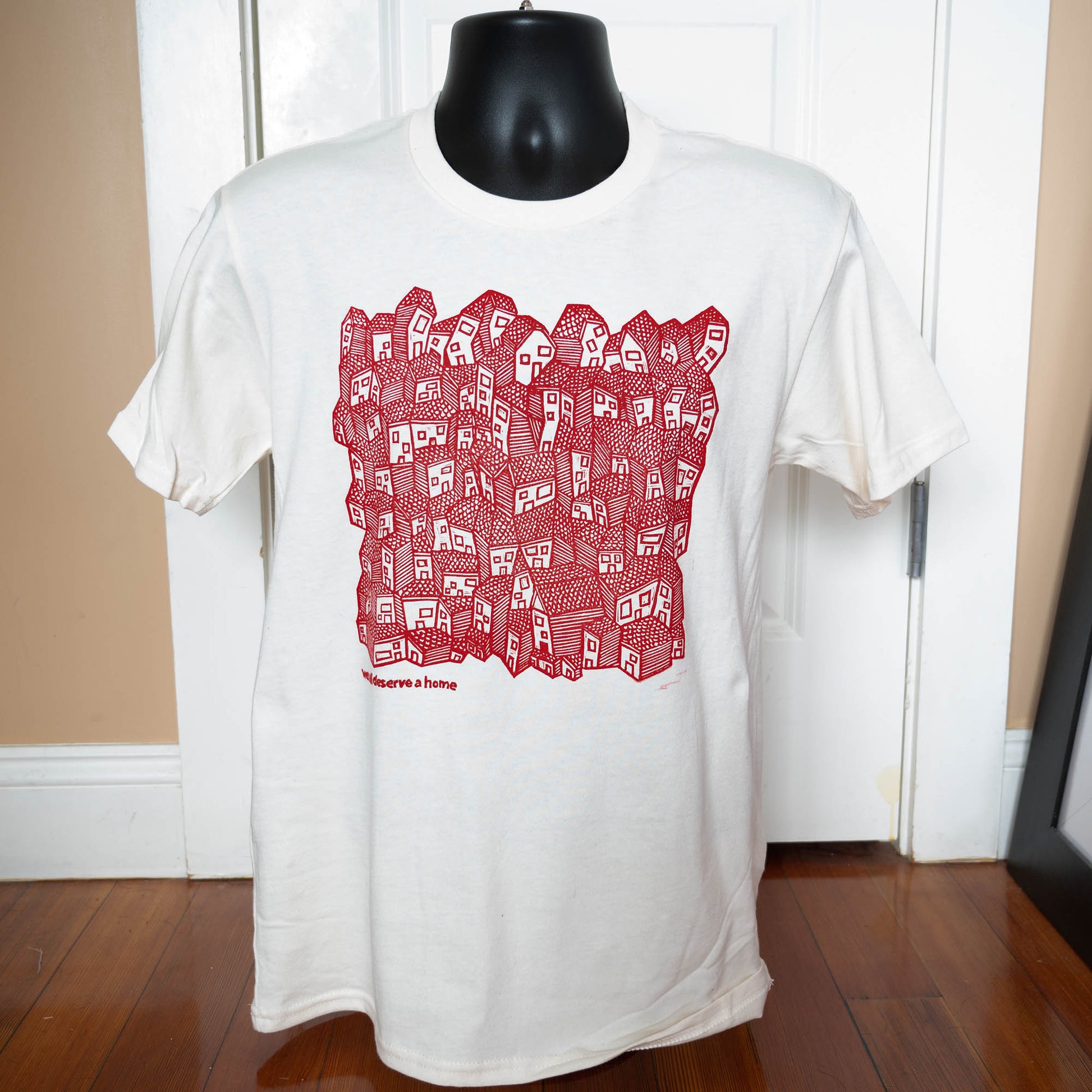 White t-shirt with red graphic design on a mannequin against a neutral background